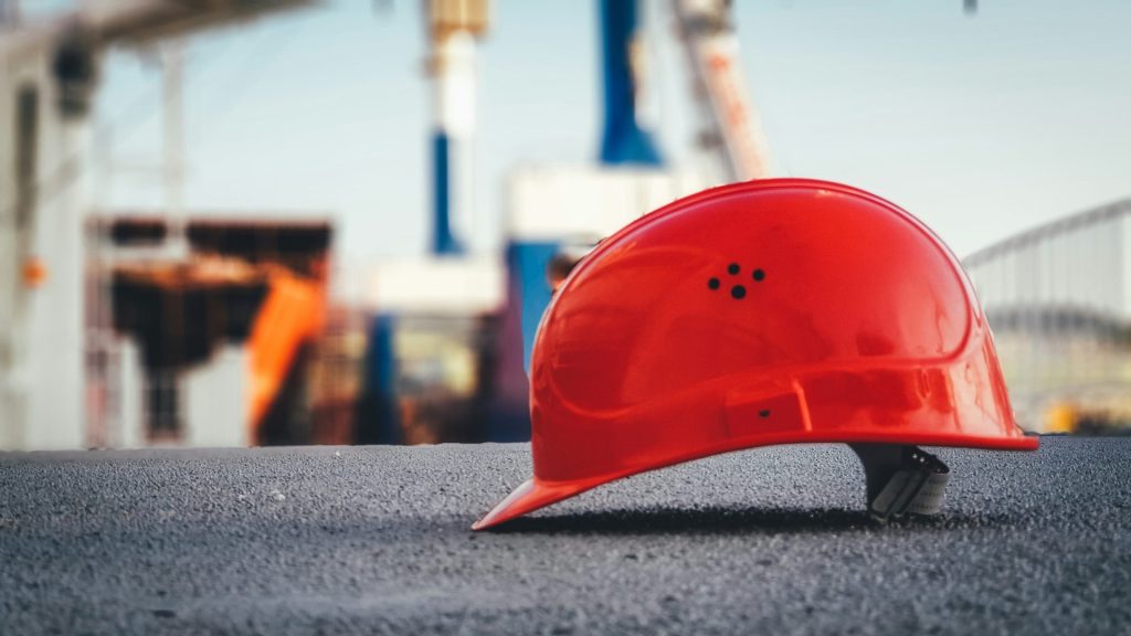 roter Bauhelm auf dem Gehweg