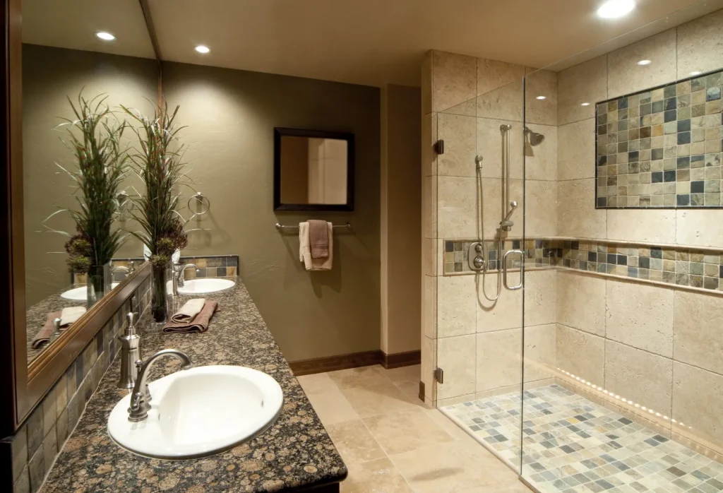 Badezimmer: Blick auf einen Waschtisch und eine gläserne Duschkabine.