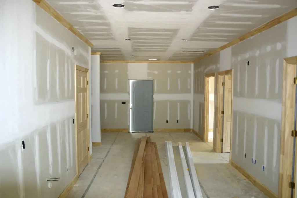Trockenbau: Ein Raum im Rohbau mit montierten Gipskartonplatten an Wänden und Decke.